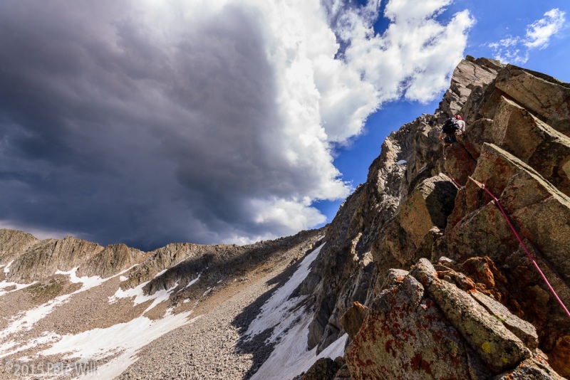 Working through some blocky terrain with ominous clouds in the distance on the lower North Ridge of the Pfeifferhorn.