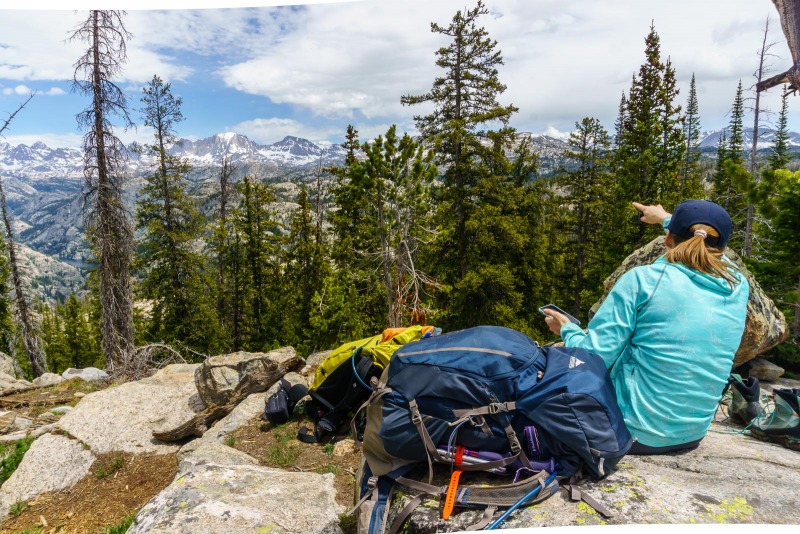 The terrain between the peaks and us is a complex mixture of bedrock, light forest, streams, and ponds.  Carly points out the prominent peaks.