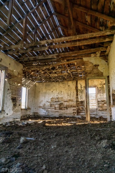 Inside one of the buildings.  Since there are no doors cows have ended up sheltering here and the floor is dried up manure.