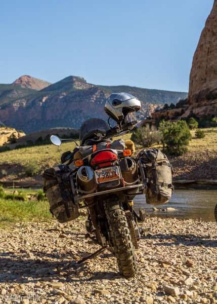 The bike down on the rocks near the river.